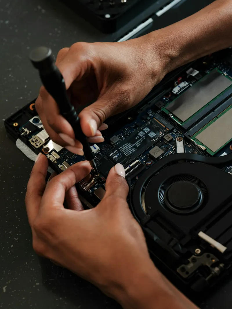 Technician upgrading a laptop with a screwdriver